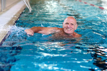 Healthy Senior Man Swimming In The Pool. Happy Pensioner Enjoying Sportive Lifestyle. Active Retirement Concept.
