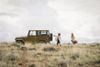 © Mint Images - Two women by a jeep in open space, loading up for a road trip.