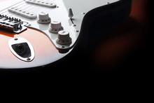Detail Of Orange Electric Guitar On Black Background
