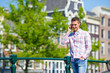 © travnikovstudio - Young caucasian man talking by cell phone on bridge in european