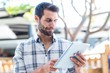 © WavebreakmediaMicro - Hipster man using tablet computer in the city