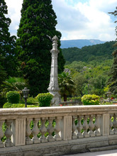 Ancient White Stone Fence With Columns And Monument In Garden