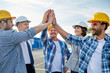 © Syda Productions - close up of builders in hardhats making high five
