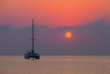 Sailing Catamaran On A Background Of A Beautiful Sunset In The Sea