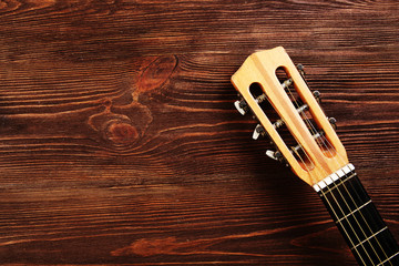 Wall Mural - Neck of acoustic guitar on wooden background