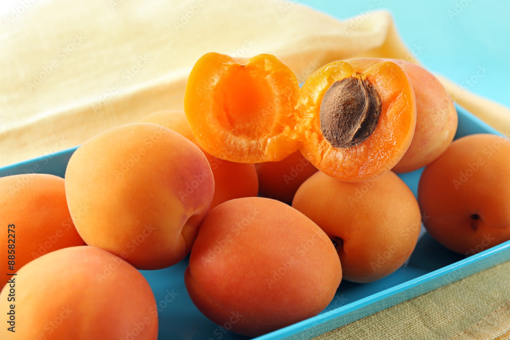 Ripe apricots on metal tray on table close up