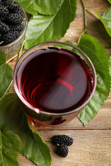 Wall Mural - Glass of refreshing mulberry juice with berries on table close up