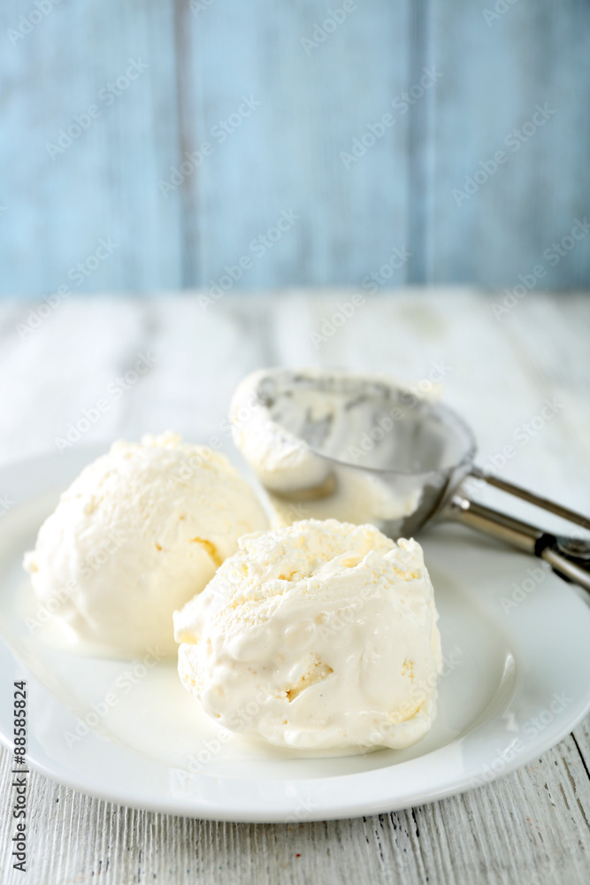 Delicious vanilla ice cream on plate, on wooden background