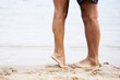 Legs of couple on beach