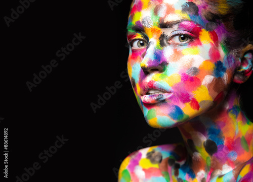 Fotografia Girl with colored face painted. Art beauty image.