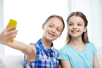 happy girls with smartphone taking selfie at home