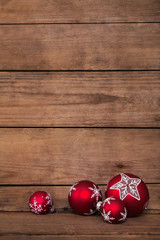 Fototapete - Rote Weihnachtskugeln auf altem Holz Hintergrund zur Dekoration.
