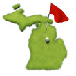 Golf ball and flag pole on course putting green shaped like the state of Michigan