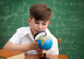 Wall Mural - Schoolboy with globe and loupe