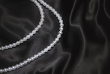 White Pearl Necklace On A Black Silk