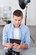 © contrastwerkstatt - fotograf im studio schaut auf sein tablet-pc