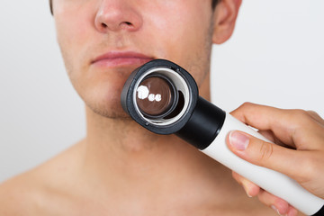 Person Hands Checking Man Face With Dermatoscope