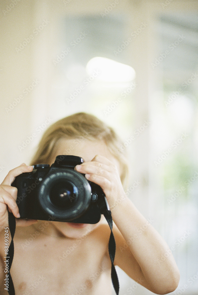 Young nude girl taking a picture with a camera. Stock Photo Adobe Stock
