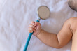 medical instruments stethoscope in hand of newborn baby girl