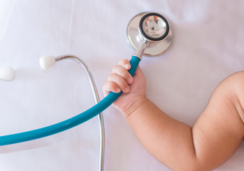 medical instruments stethoscope in hand of newborn baby girl