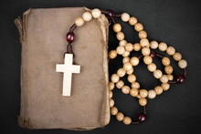 Rosary And Prayer Book On A Dark Background