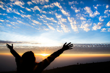 Girl silhouette with open arms freedom feeling over sunrise back