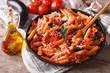 Penne with eggplant and tomatoes closeup and ingredients. horizontal
