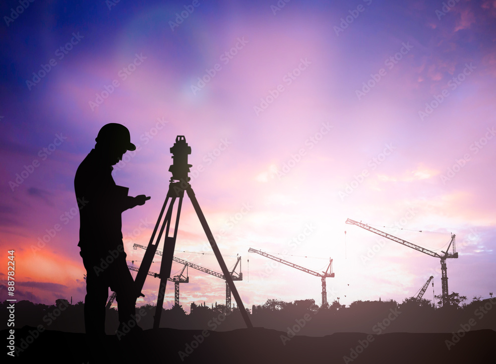 silhouette survey engineer working  in a building site over Blur - obrazy, fototapety, plakaty 