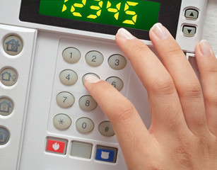 woman entering security code to alarm system