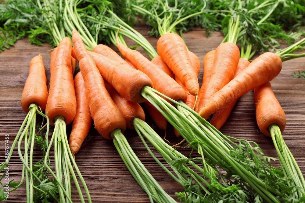 Fresh organic carrots on wooden table, closeup