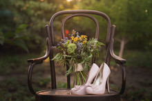 Beautiful Wedding Shoes With High Heels And A Bouquet Of Colorful Flowers On A Vintage Chair On The Nature In Sunset Light, Decorations, Preparing For The Wedding, Details, Boudoir