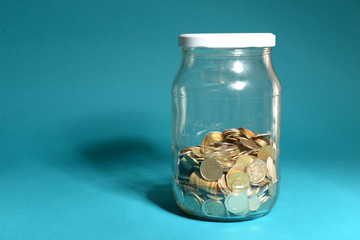 Sticker - Glass jar with coins on blue background