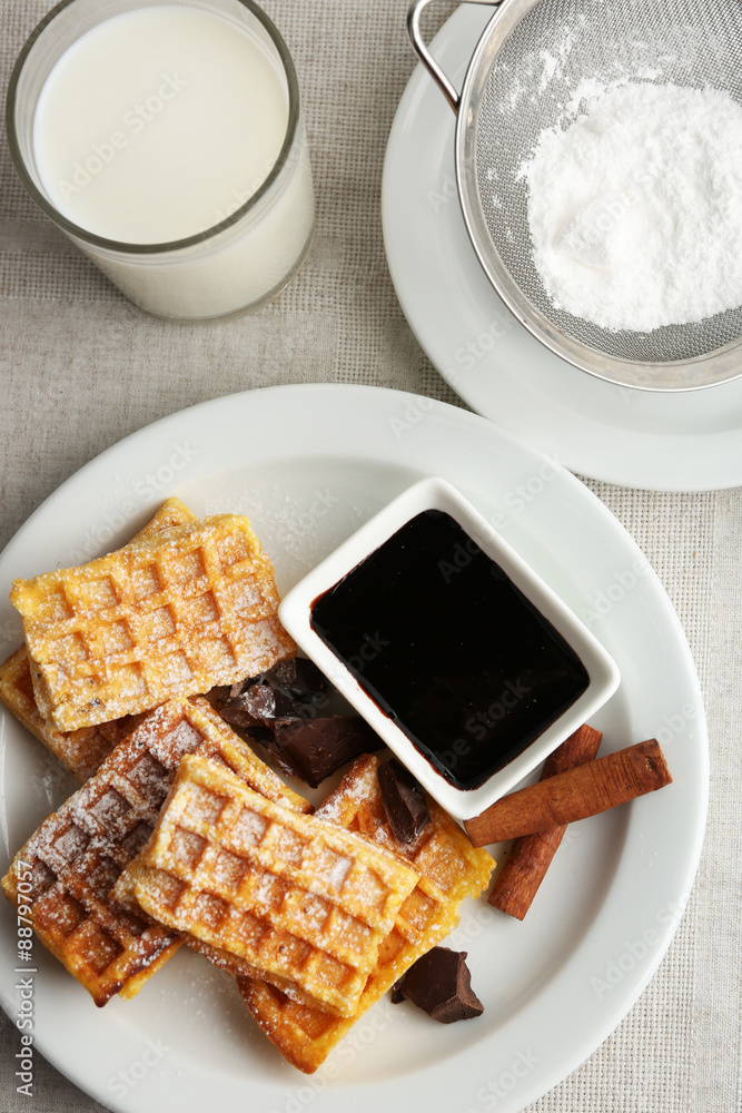 Sweet homemade waffles on plate, on light background