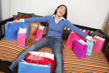 A Smiling Woman With Her Arms And Legs Outstretched Among Her Shopping Bags.