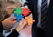 business people assembling jigsaw