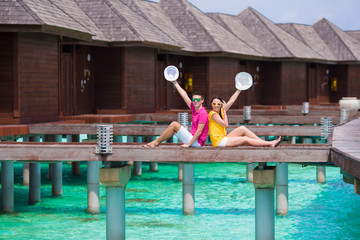 Wall Mural - Young couple on beach jetty near water villa in honeymoon