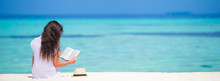 Young Woman Reading On Tropical White Beach