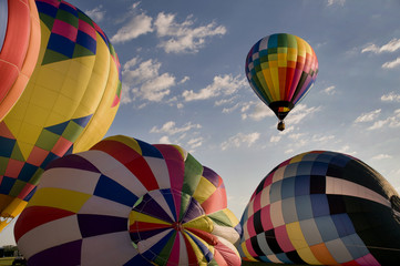 Wall Mural - Hot air balloon floating over other inflating balloons