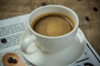 © DN6 - White cup of Espresso with Newspaper on the wooden table in the