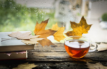 Cup Of Tea On A Wooden Window Sill With Books And Autumn Leaves On A Natural Background