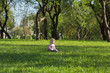 Girl in park sitting on the green grass