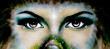 women eyes, small rainbow colored peacock feather. Eye contact.