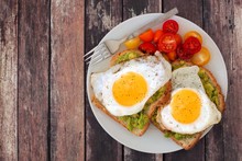 Healthy Avocado, Egg Open Sandwiches On A Plate With Colorful Tomatoes Against Rustic Wood