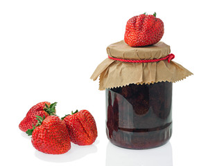 Glass jar of strawberry jam with berries isolated on white backg