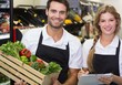 © WavebreakMediaMicro - Portrait of two colleagues holding a box with fresh vegetables
