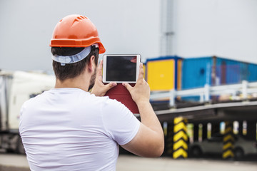 Builder man working with a tablet in a protective helmet