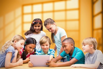 Wall Mural - Composite image of cute pupils using tablet computer in library 