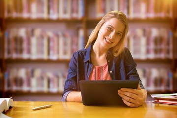 Canvas Print - Composite image of student studying in the library with tablet