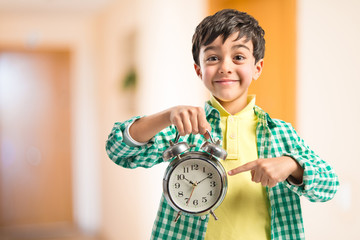 Boy holding an antique clock over white background