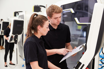 Wall Mural - Two Young Engineers Operating CNC Machinery On Factory Floor